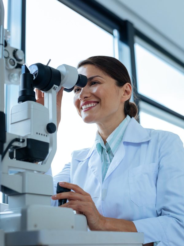 cheerful-female-doctor-looking-into-the-microscope.jpg
